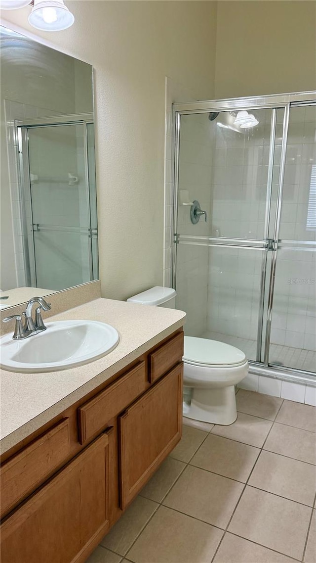 full bath with vanity, toilet, a shower stall, and tile patterned flooring