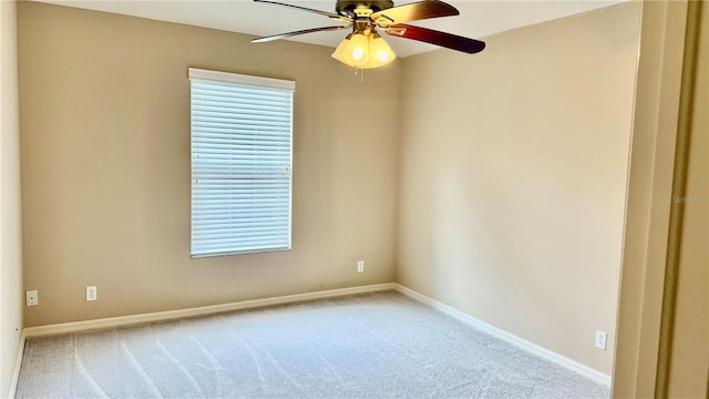 empty room featuring a ceiling fan, carpet, and baseboards