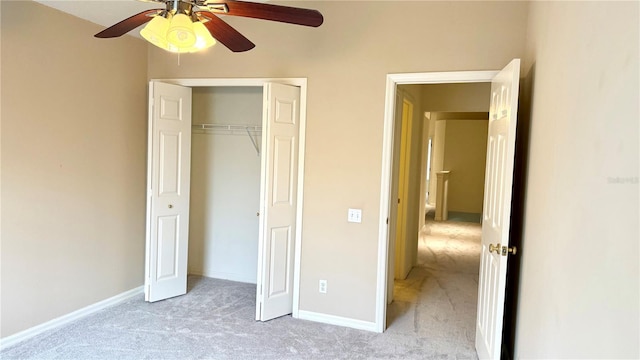 unfurnished bedroom with a closet, light colored carpet, a ceiling fan, and baseboards