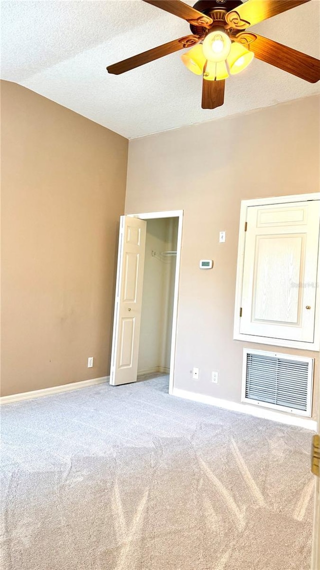 carpeted spare room with baseboards, visible vents, a textured ceiling, and ceiling fan