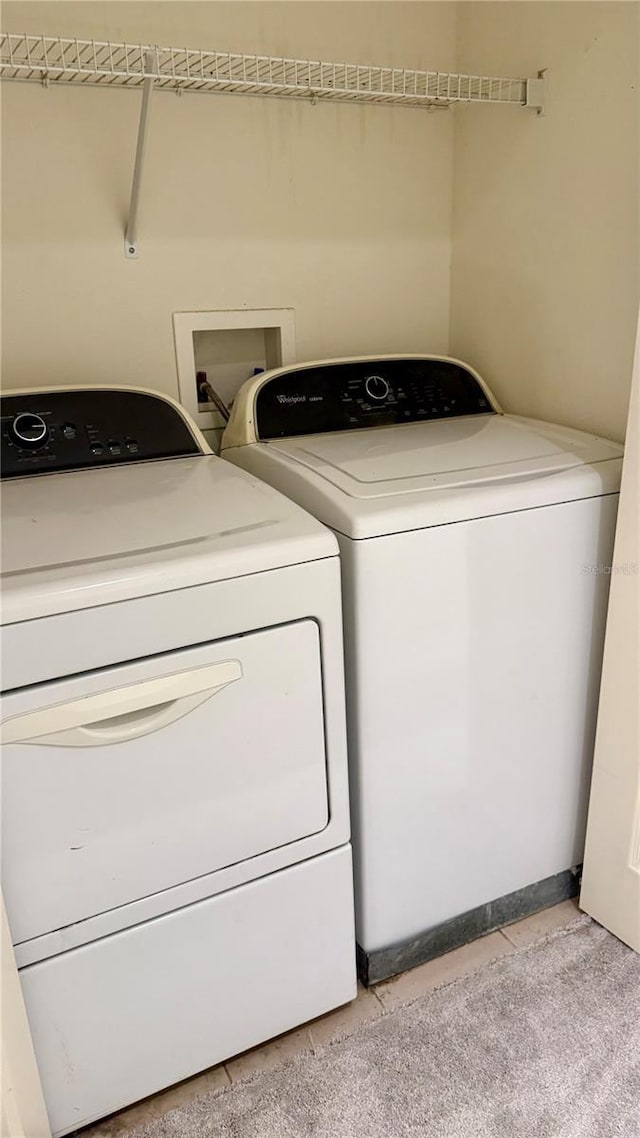 laundry area with light tile patterned floors, laundry area, and separate washer and dryer