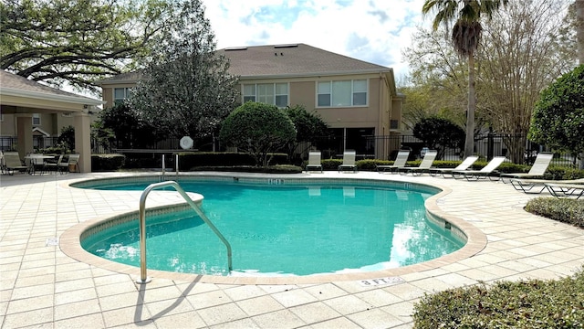 community pool featuring a patio and fence