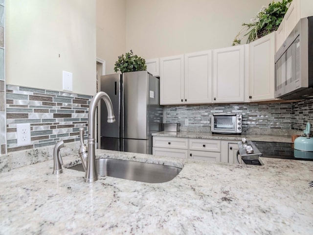 5100 Burchette Rd Unit 500, Tampa, FL 33647 - kitchen featuring a toaster, backsplash, stainless steel appliances, and a sink