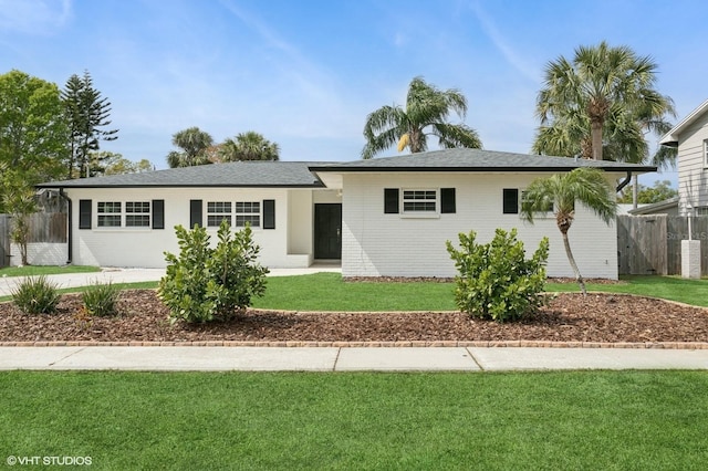 single story home with brick siding, a front lawn, and fence