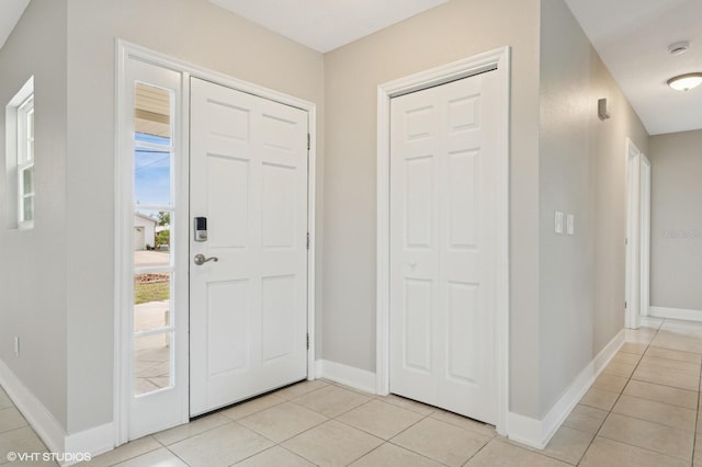 foyer with light tile patterned floors and baseboards