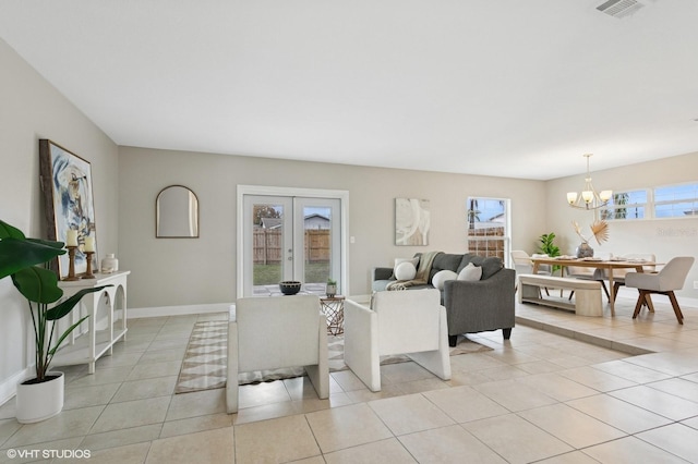 living area with a notable chandelier, french doors, baseboards, and light tile patterned floors