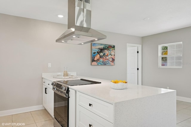 kitchen with light stone countertops, light tile patterned floors, stainless steel electric range, island range hood, and white cabinets