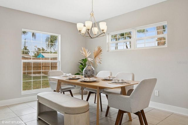 dining room with light tile patterned flooring, baseboards, and an inviting chandelier