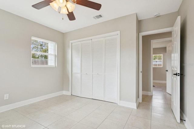 unfurnished bedroom with multiple windows, baseboards, visible vents, and a closet