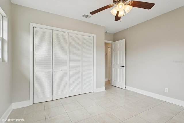 unfurnished bedroom featuring visible vents, light tile patterned floors, baseboards, and a closet