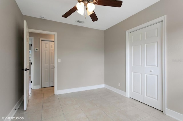 unfurnished bedroom featuring light tile patterned floors, baseboards, visible vents, and ceiling fan