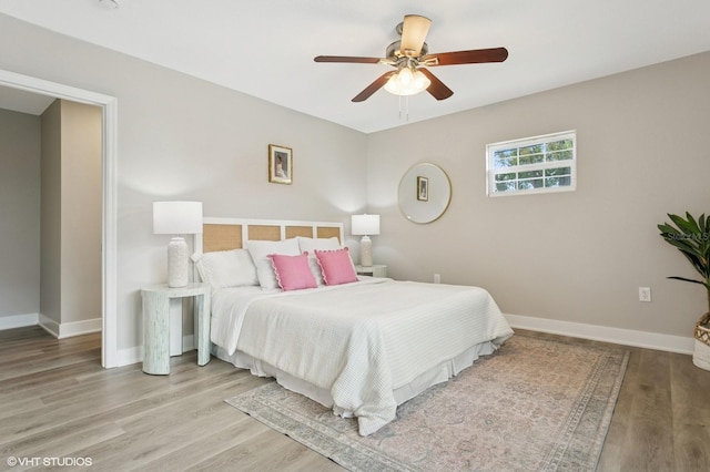 bedroom featuring a ceiling fan, light wood-type flooring, and baseboards