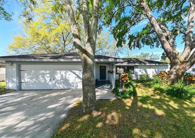 view of front of property featuring concrete driveway, a garage, and a front yard