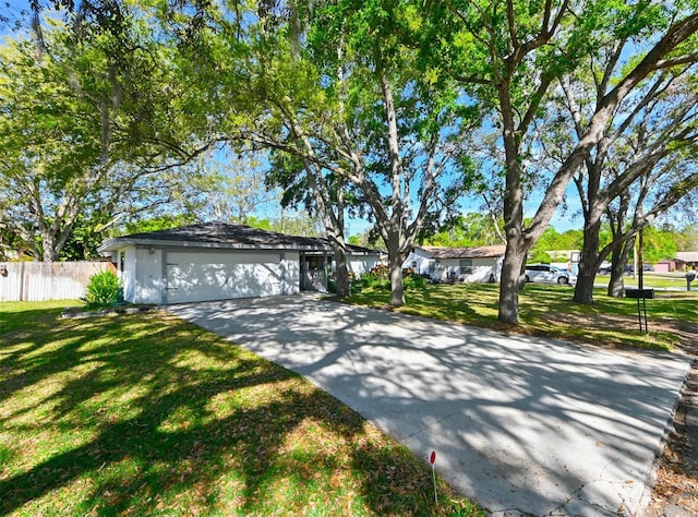 single story home featuring a garage, driveway, a front lawn, and fence