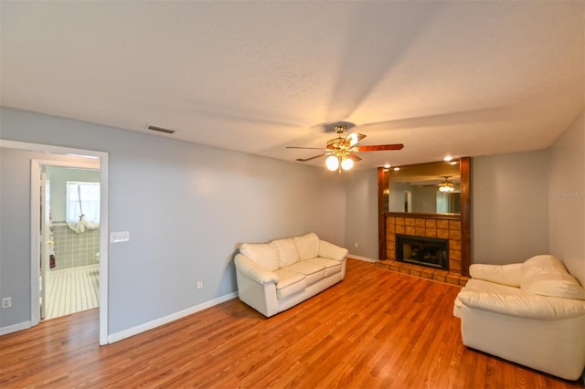 living room featuring baseboards, visible vents, light wood finished floors, and ceiling fan