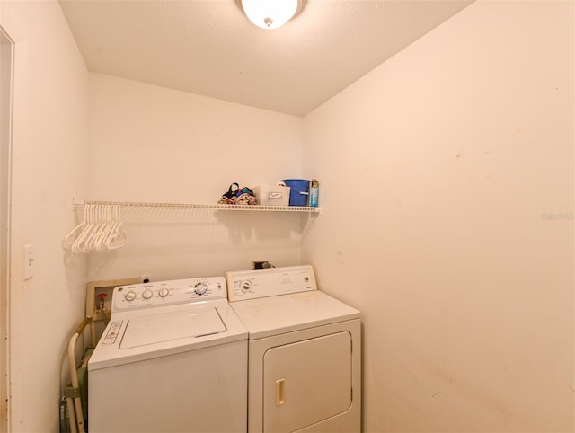 clothes washing area featuring washing machine and clothes dryer and laundry area