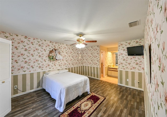 bedroom featuring wallpapered walls, wood finished floors, visible vents, and baseboards