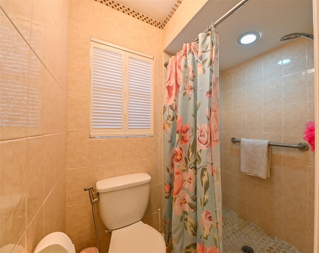 bathroom featuring toilet, tile walls, and a tile shower