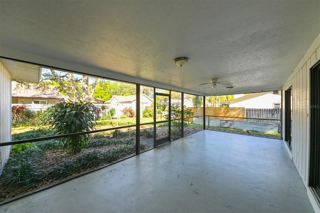 unfurnished sunroom with ceiling fan