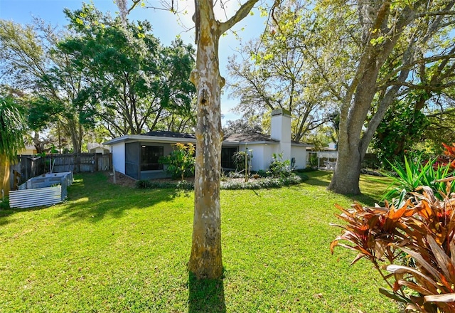 view of yard with a vegetable garden and fence