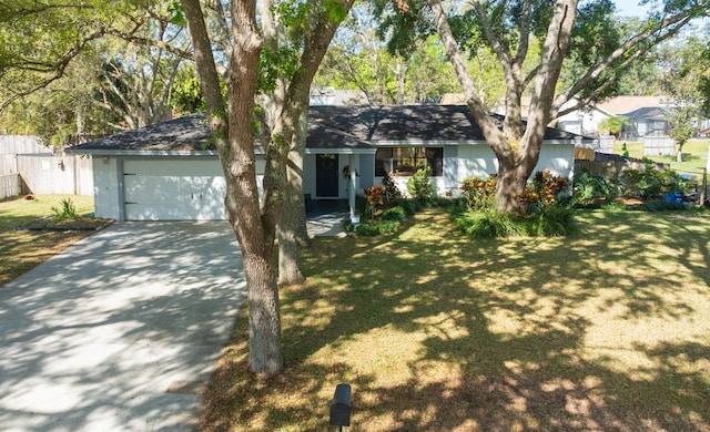 ranch-style house with a front lawn, concrete driveway, fence, and an attached garage