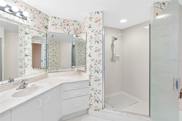 full bath with tile patterned floors, vanity, a shower stall, and wallpapered walls