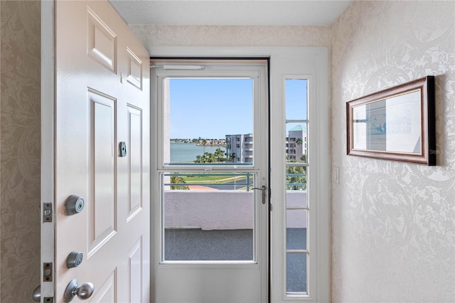 doorway with wallpapered walls and a water view