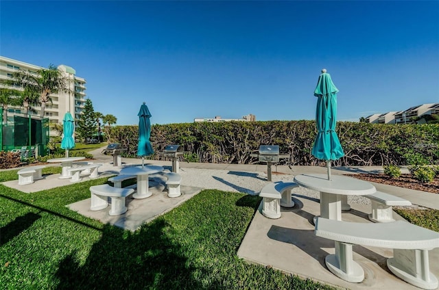 view of community with a patio and a lawn