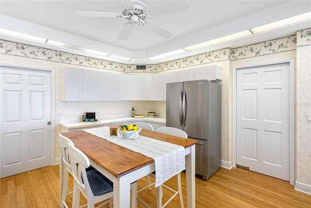 kitchen featuring light wood finished floors, ceiling fan, light countertops, and freestanding refrigerator