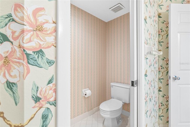 bathroom with baseboards, visible vents, wallpapered walls, tile patterned floors, and toilet