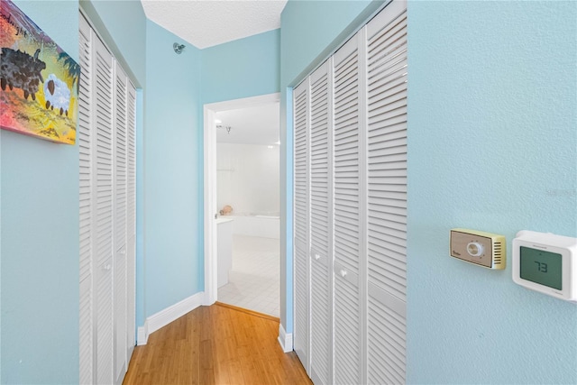 hall featuring wood finished floors and baseboards