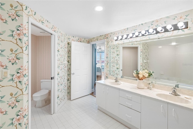 bathroom with a sink, toilet, tile patterned floors, and wallpapered walls