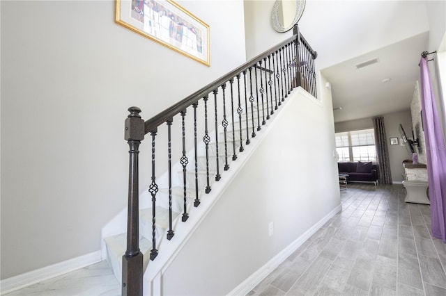 staircase with baseboards and visible vents