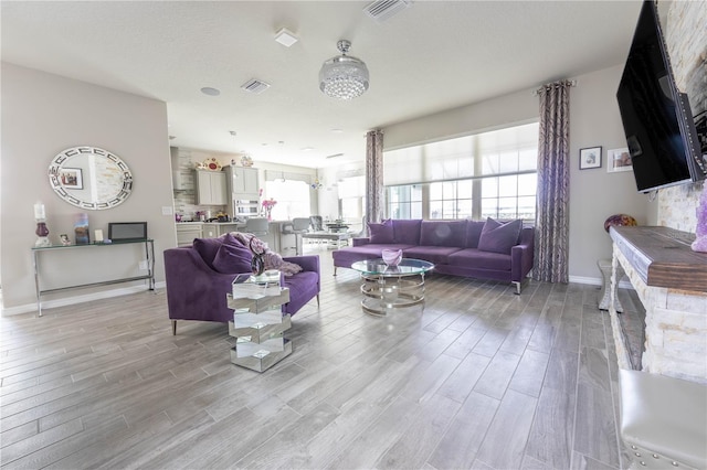 living area with visible vents, baseboards, and light wood-style floors