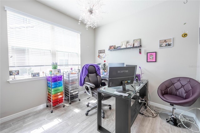 office area featuring plenty of natural light, wood finished floors, baseboards, and a chandelier