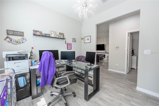 home office with baseboards, an inviting chandelier, and wood finished floors