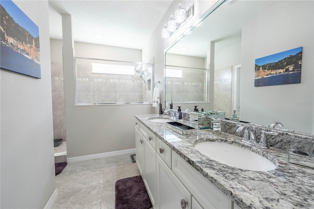 bathroom featuring a sink, baseboards, walk in shower, and double vanity