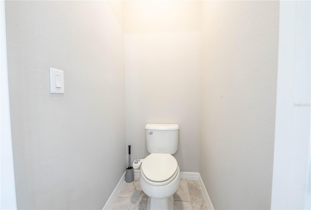 bathroom featuring toilet and baseboards