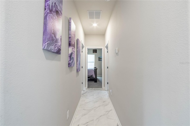 corridor with visible vents, baseboards, and marble finish floor