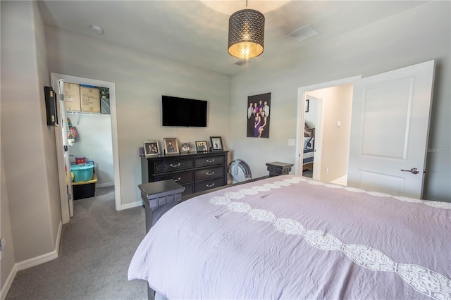 carpeted bedroom featuring a walk in closet, baseboards, a closet, and visible vents