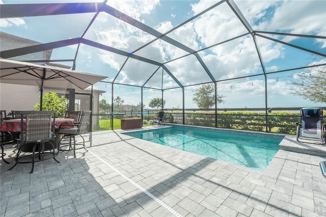 outdoor pool featuring glass enclosure and a patio area