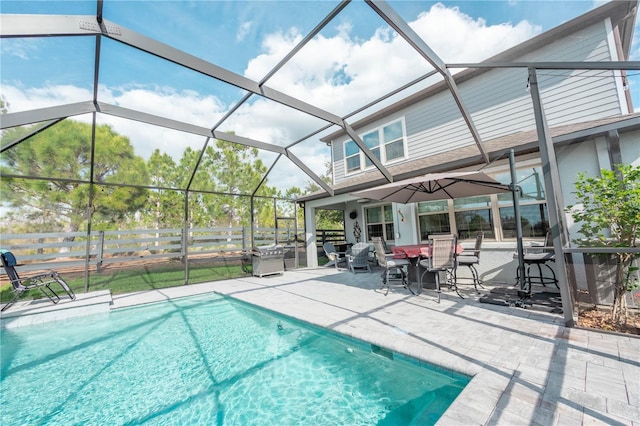 outdoor pool with fence, a lanai, and a patio area