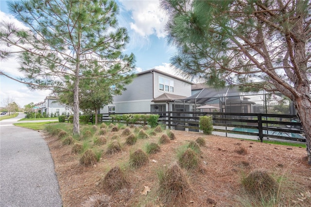 view of yard featuring glass enclosure and fence