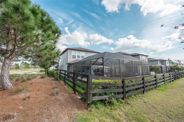 exterior space featuring a lanai and fence