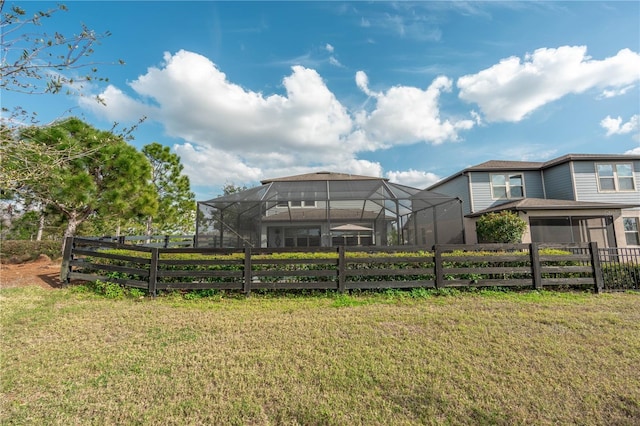 view of yard with glass enclosure and fence