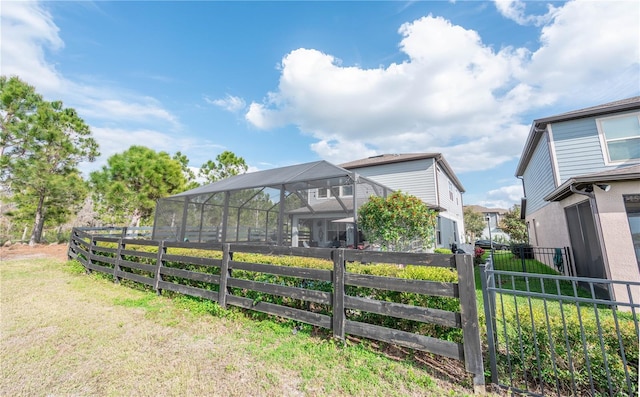 view of yard with a lanai and fence