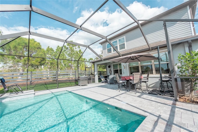 outdoor pool featuring a lanai, fence, and a patio