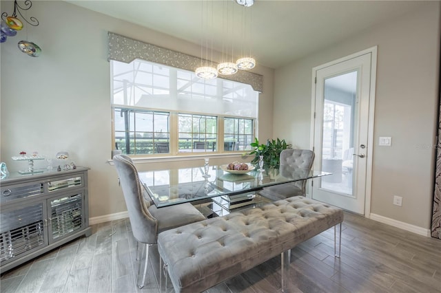 dining room with a notable chandelier, baseboards, and wood finished floors