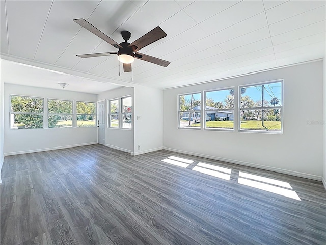 unfurnished room featuring baseboards, dark wood-style flooring, and ceiling fan