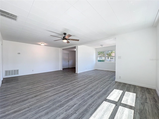 empty room featuring dark wood finished floors, visible vents, baseboards, and a ceiling fan